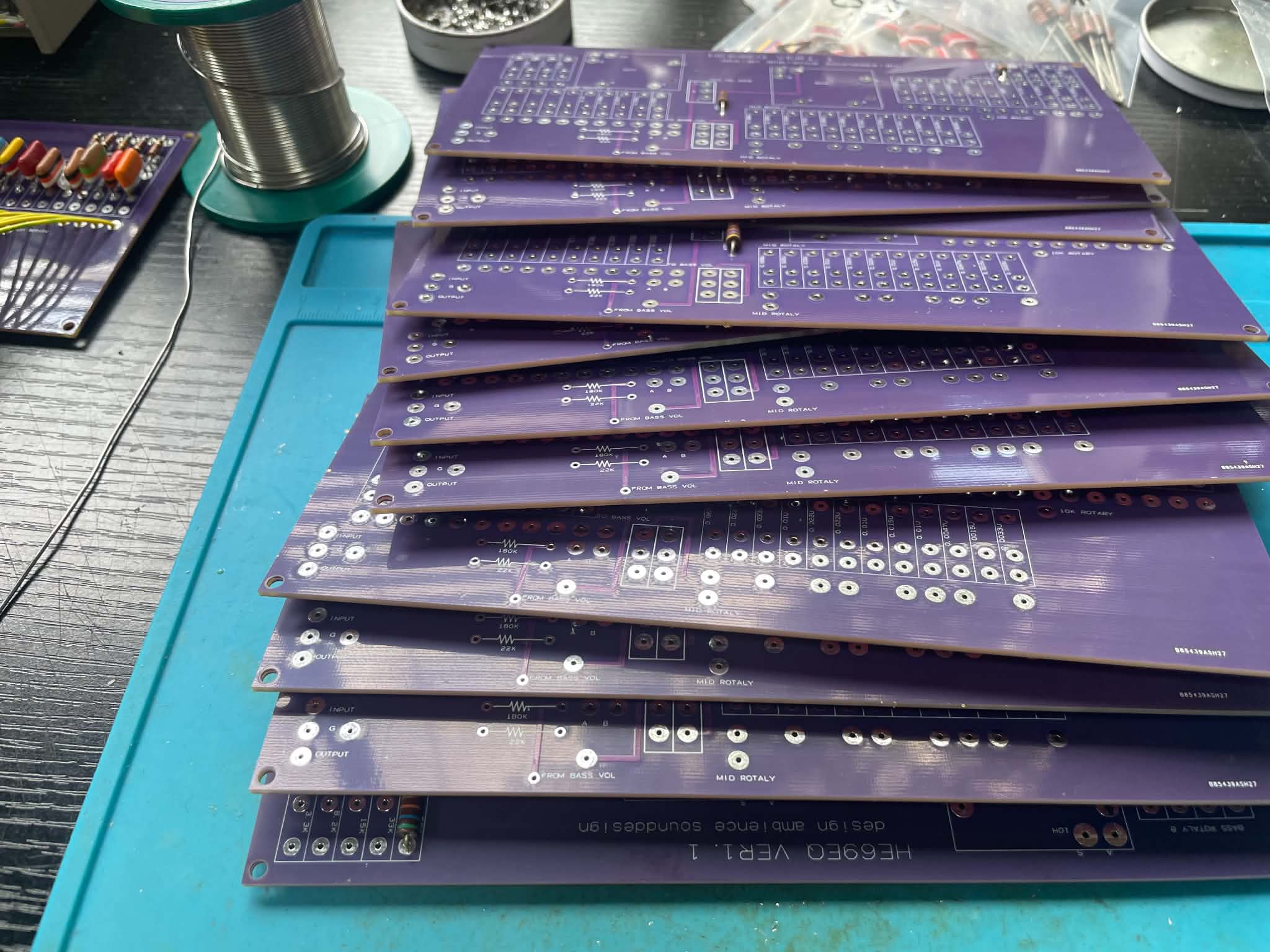 自社設計の HE69EQ 基板が積み上げられた作業机